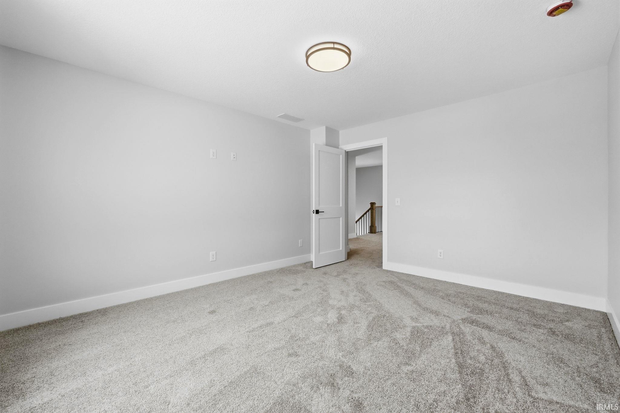 Empty room with baseboards and light colored carpet