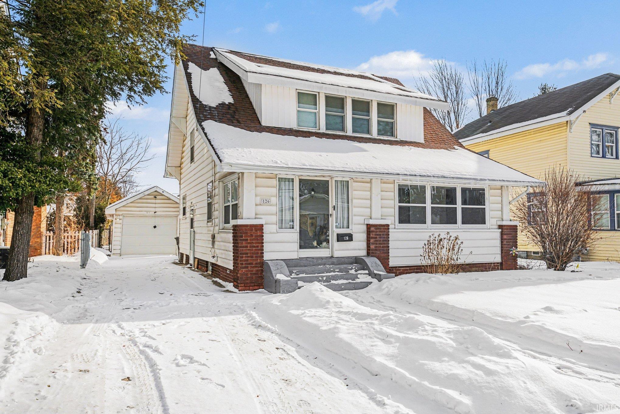View of front of property featuring an outdoor structure and a garage