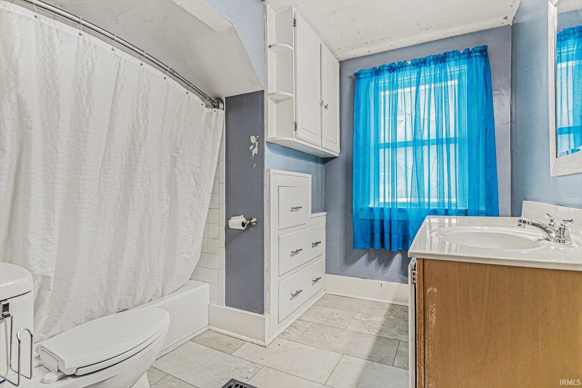 Full bathroom featuring vanity and shower / bathtub combination with curtain