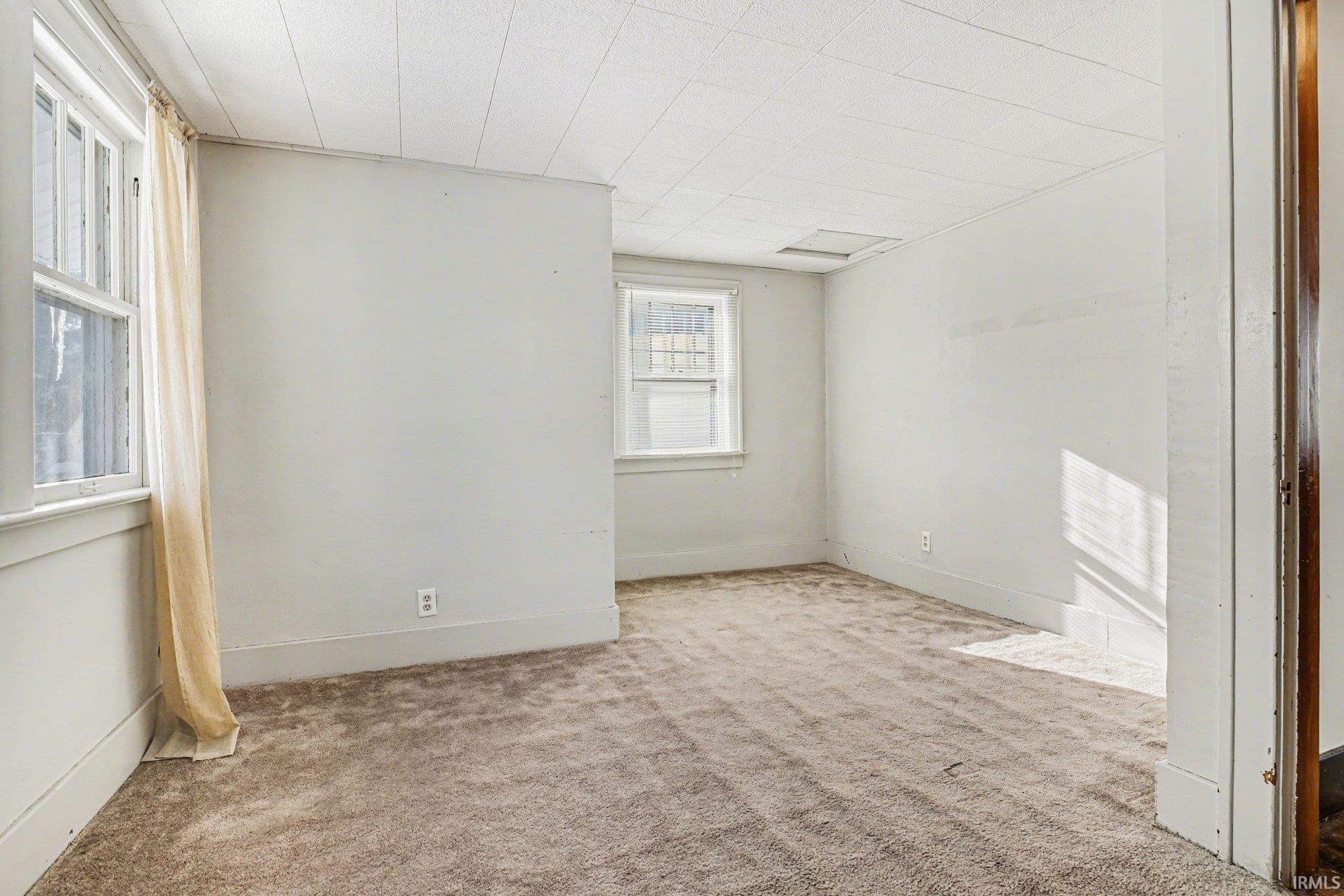Unfurnished room featuring carpet floors and baseboards