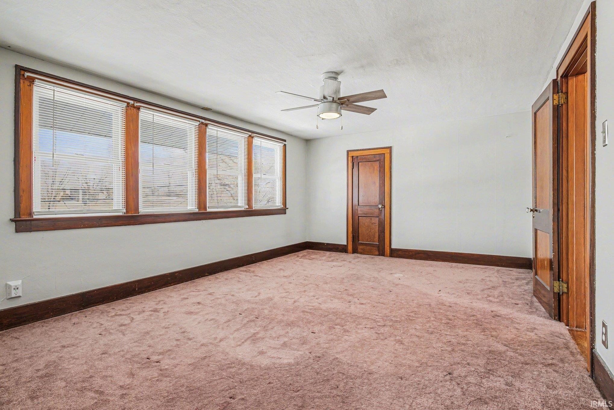 Unfurnished bedroom featuring a ceiling fan and carpet floors