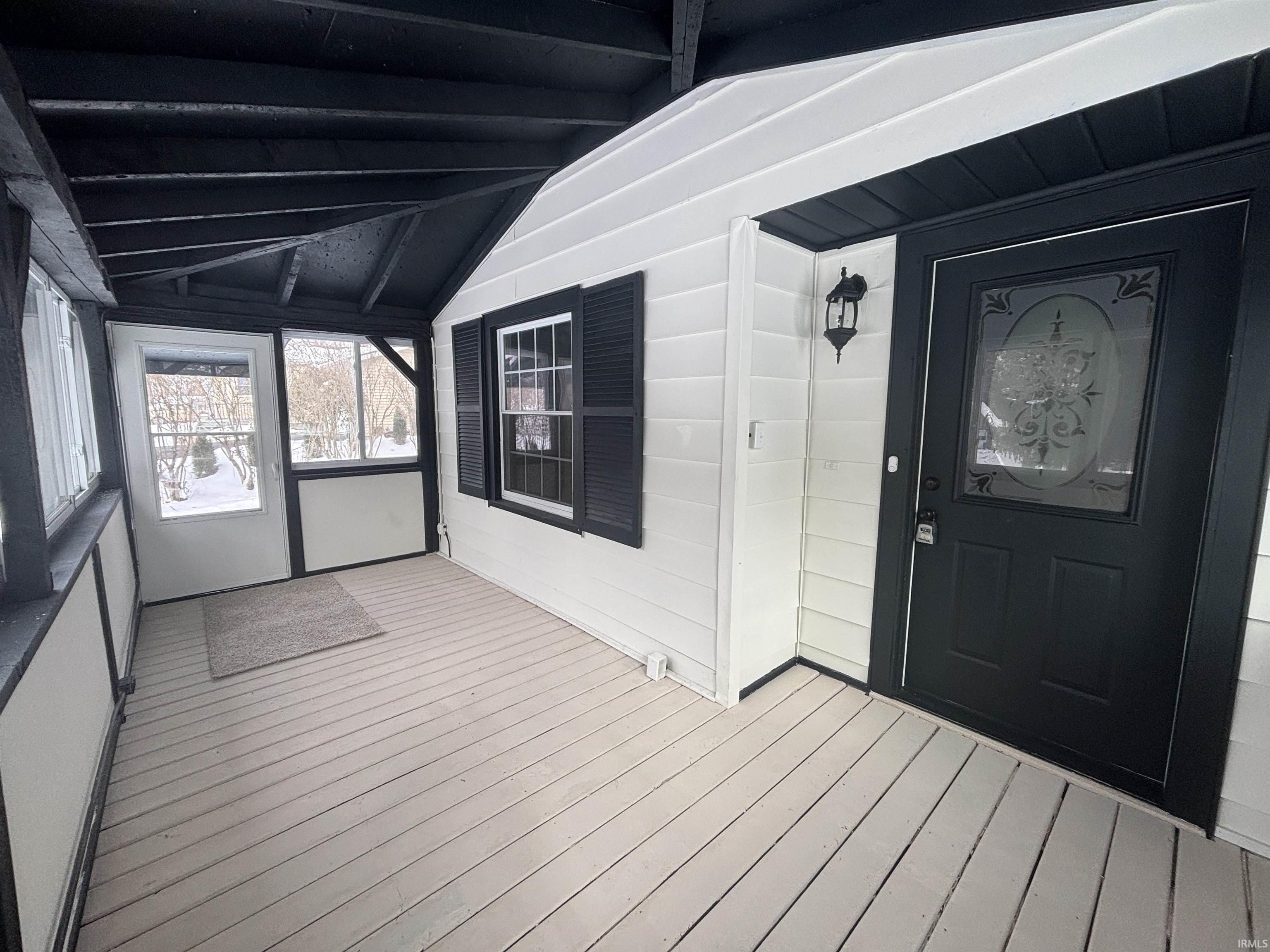 Entrance to property featuring a sunroom and a deck