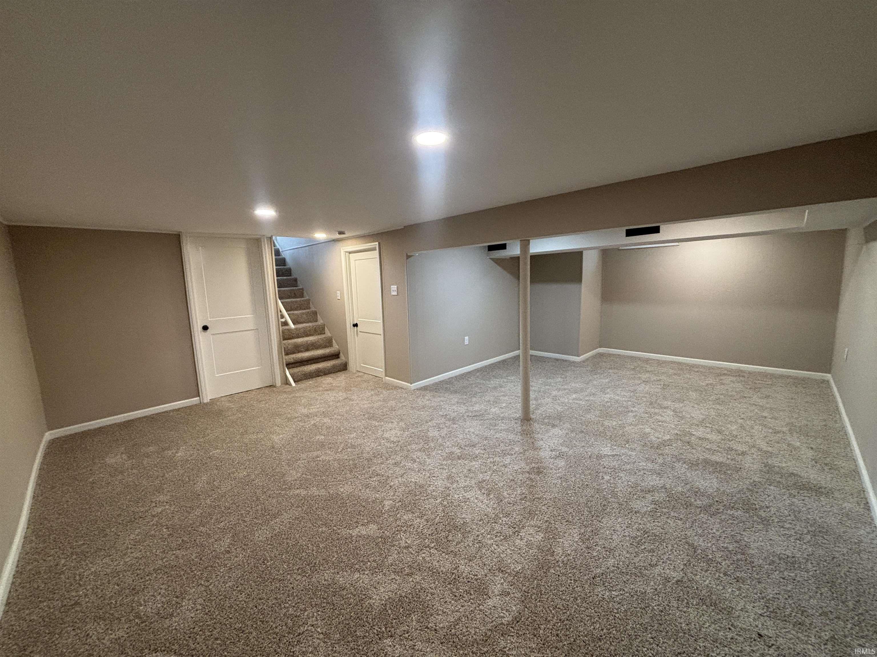 Finished below grade area with stairway and carpet flooring