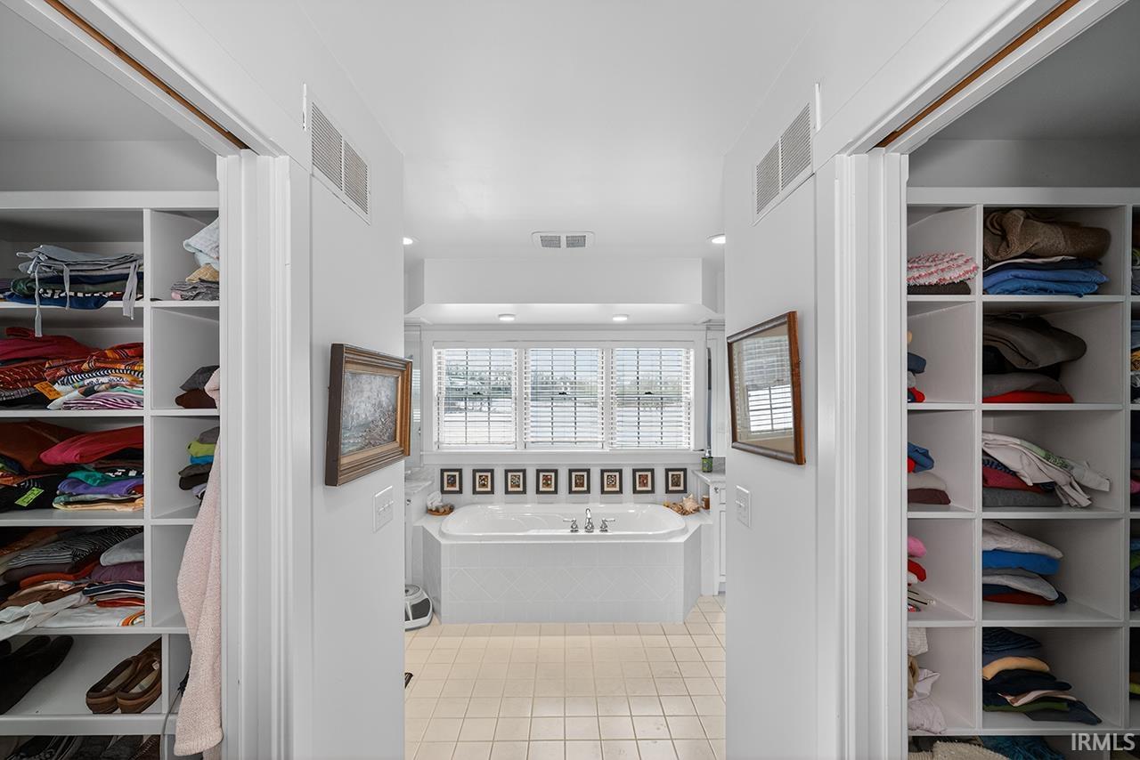Full bathroom featuring a spacious closet, a bath, light tile patterned flooring, and recessed lighting
