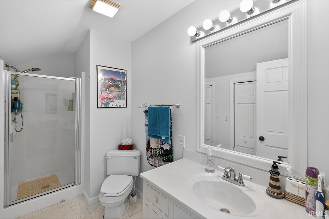 Full bath featuring a stall shower, vanity, and light tile patterned flooring