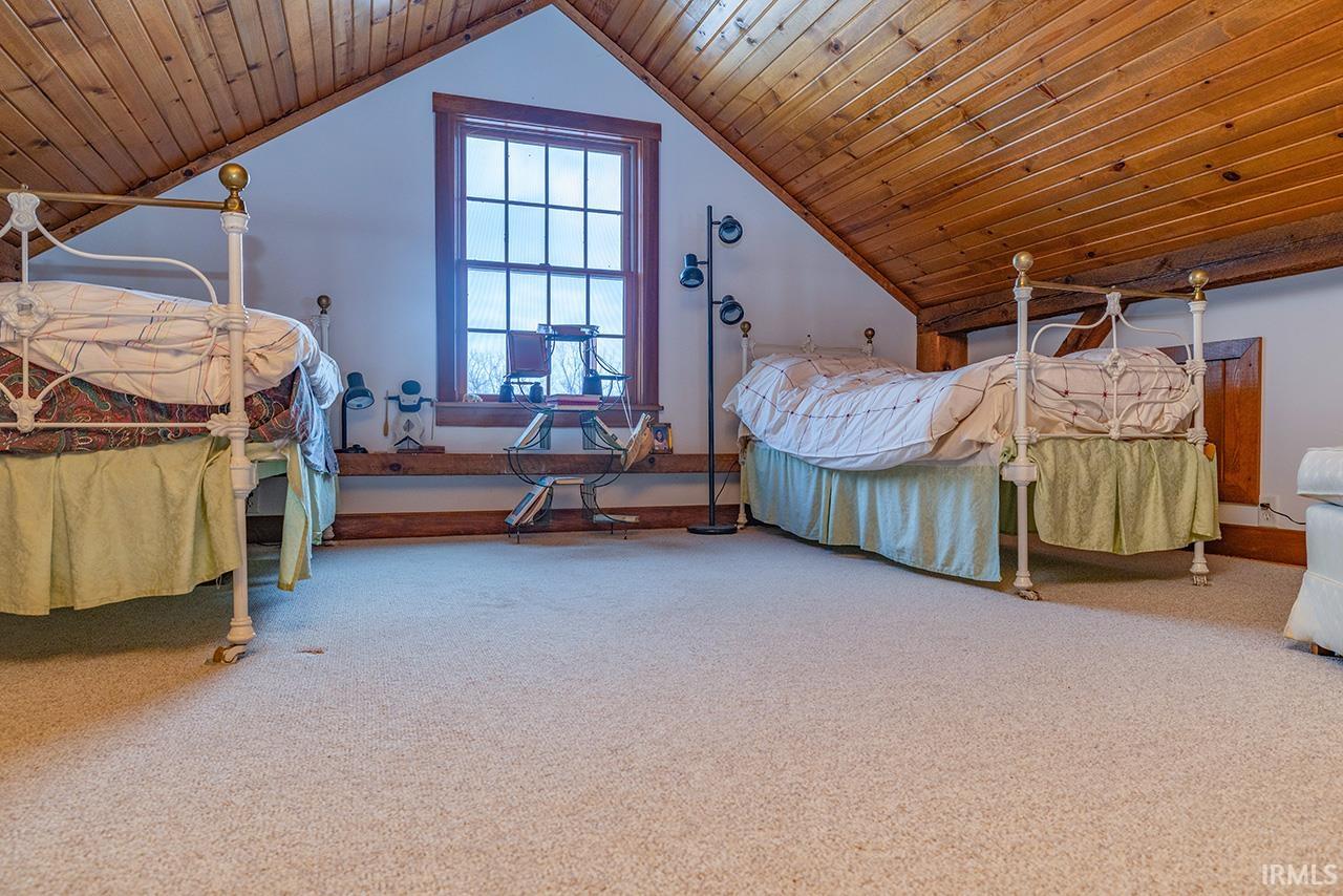 Bedroom with wood ceiling and carpet flooring