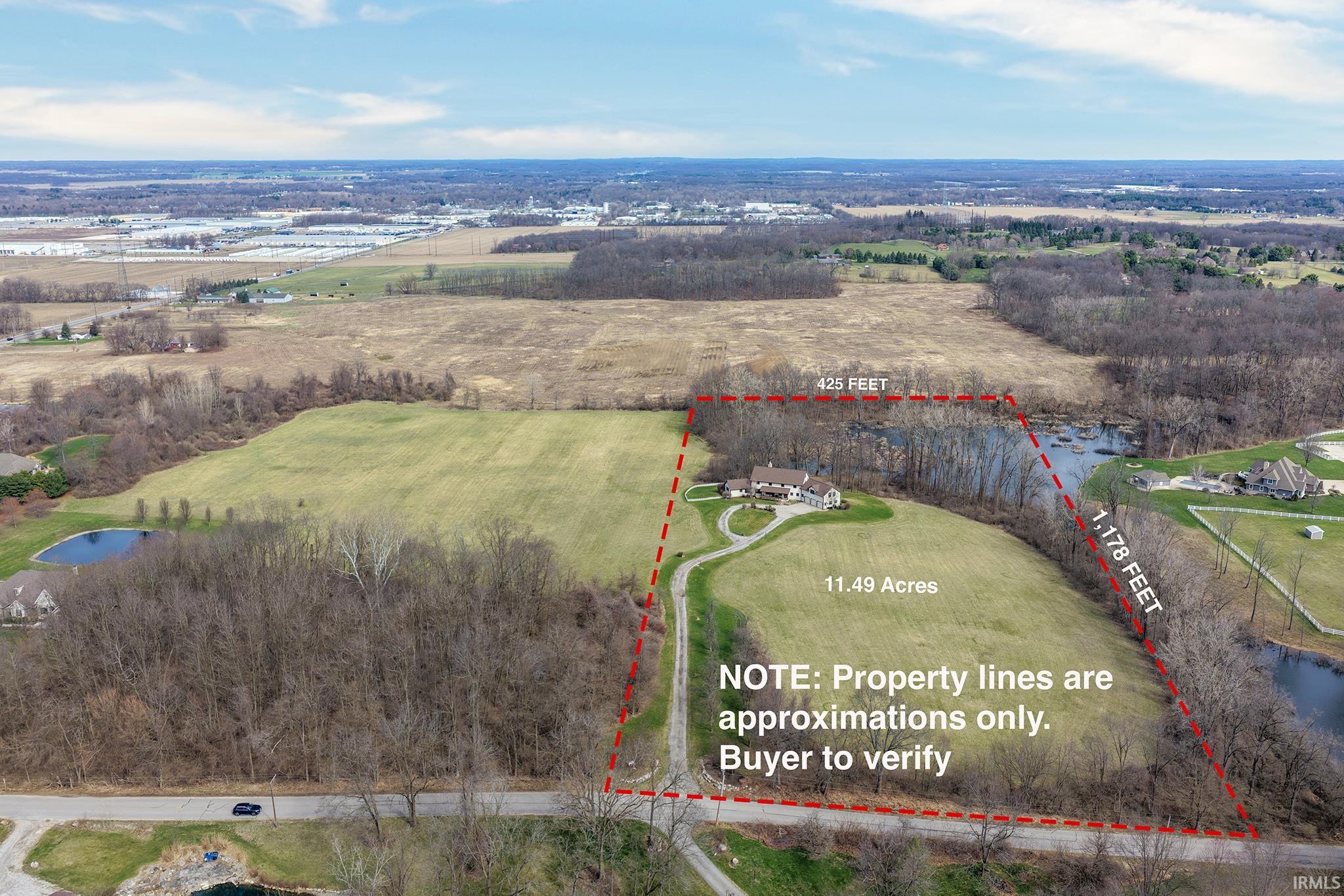 Expansive 11.49-acre property featuring a residential structure with a winding driveway
