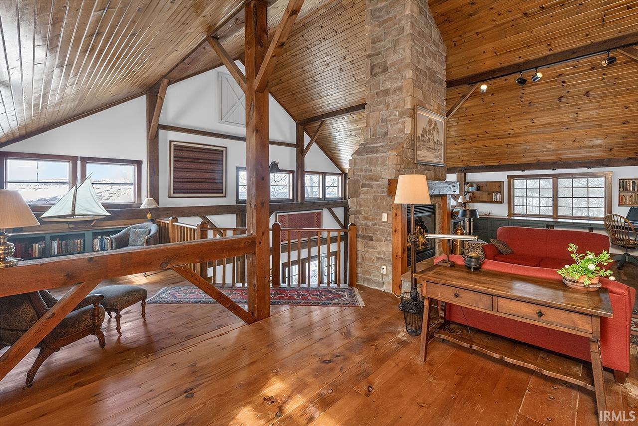 Living room featuring a vaulted wooden ceiling, wood-type flooring, and healthy amount of natural light