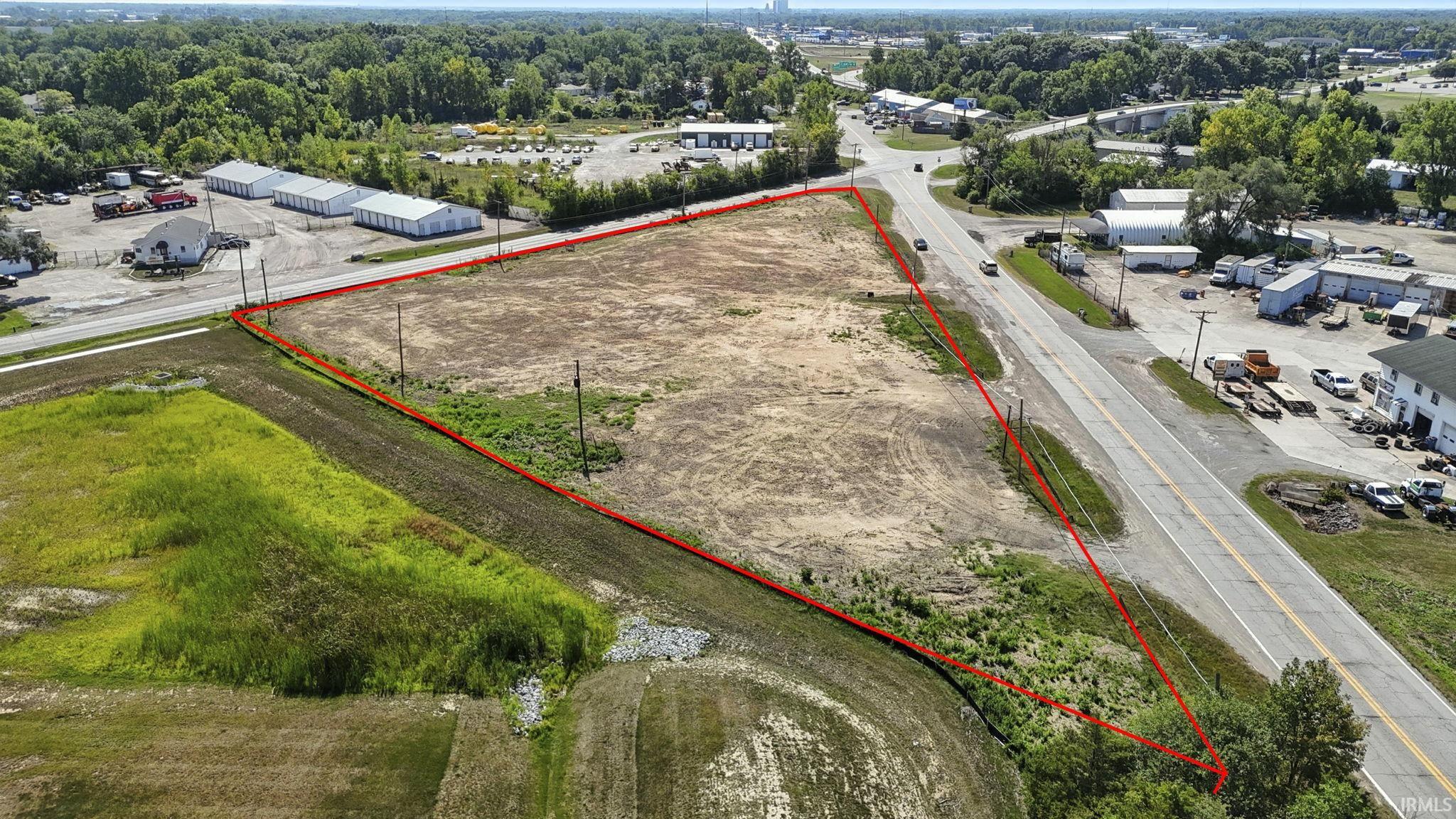 Aerial view of property and surrounding area featuring industrial structures and property boundaries highlighted