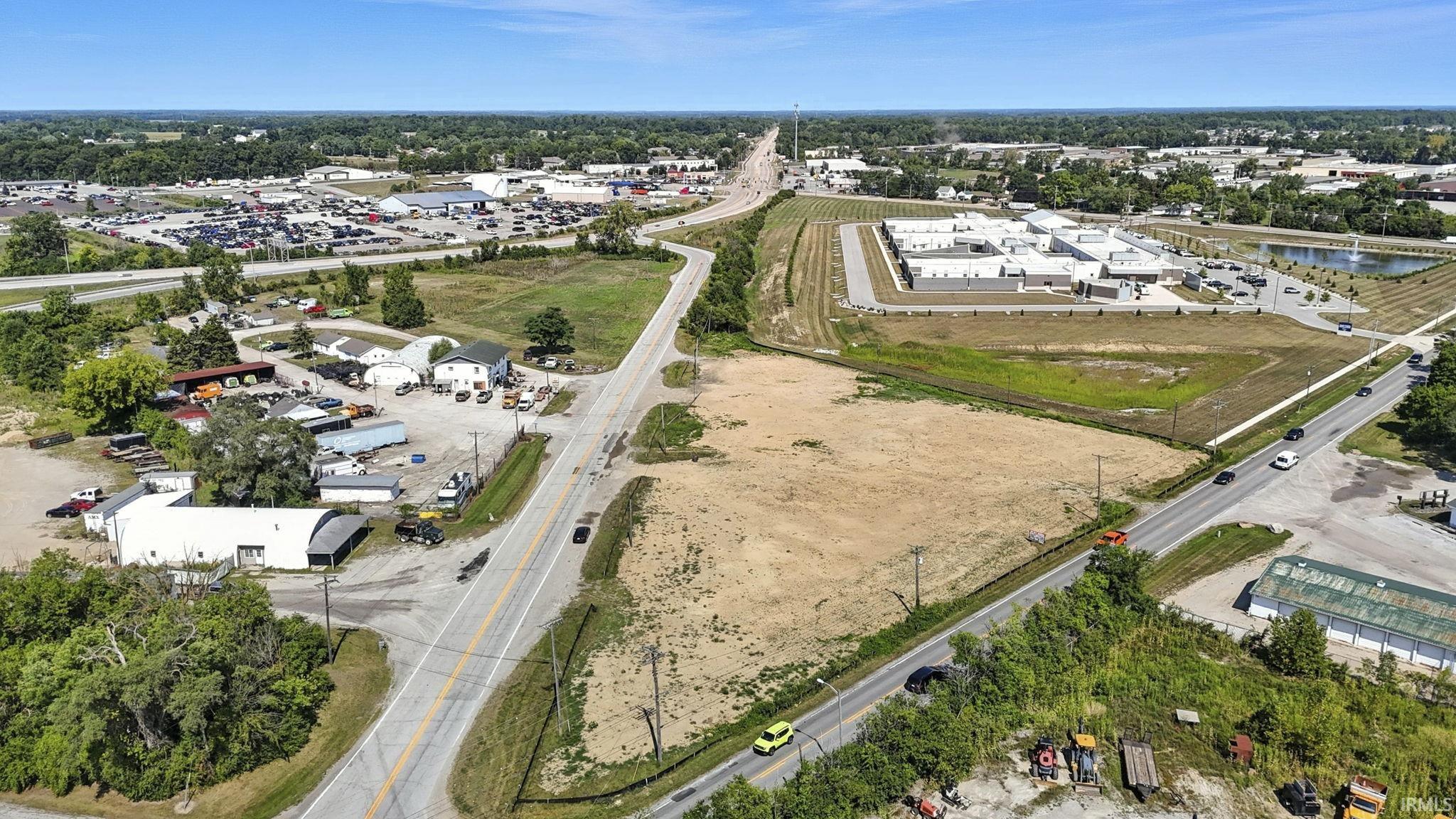 Aerial view of property and surrounding area featuring industrial structures