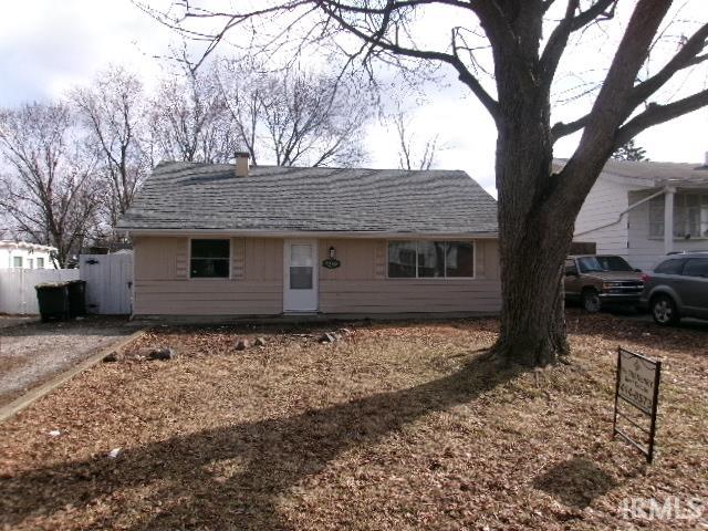 Single story home featuring a chimney and roof with shingles