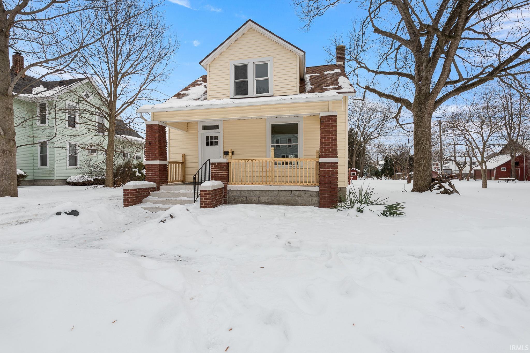 Bungalow featuring covered porch and a chimney