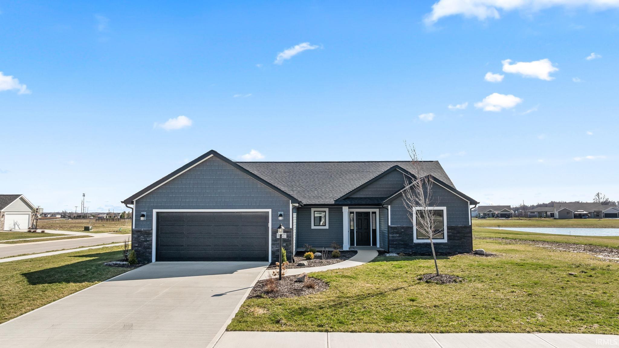 Craftsman-style house with a front yard, driveway, a garage, stone siding, and a residential view