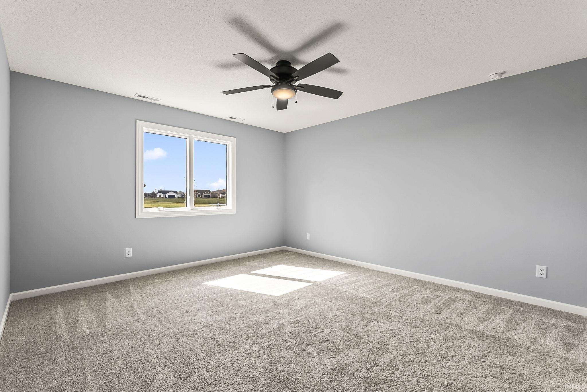 Spare room featuring ceiling fan and light carpet