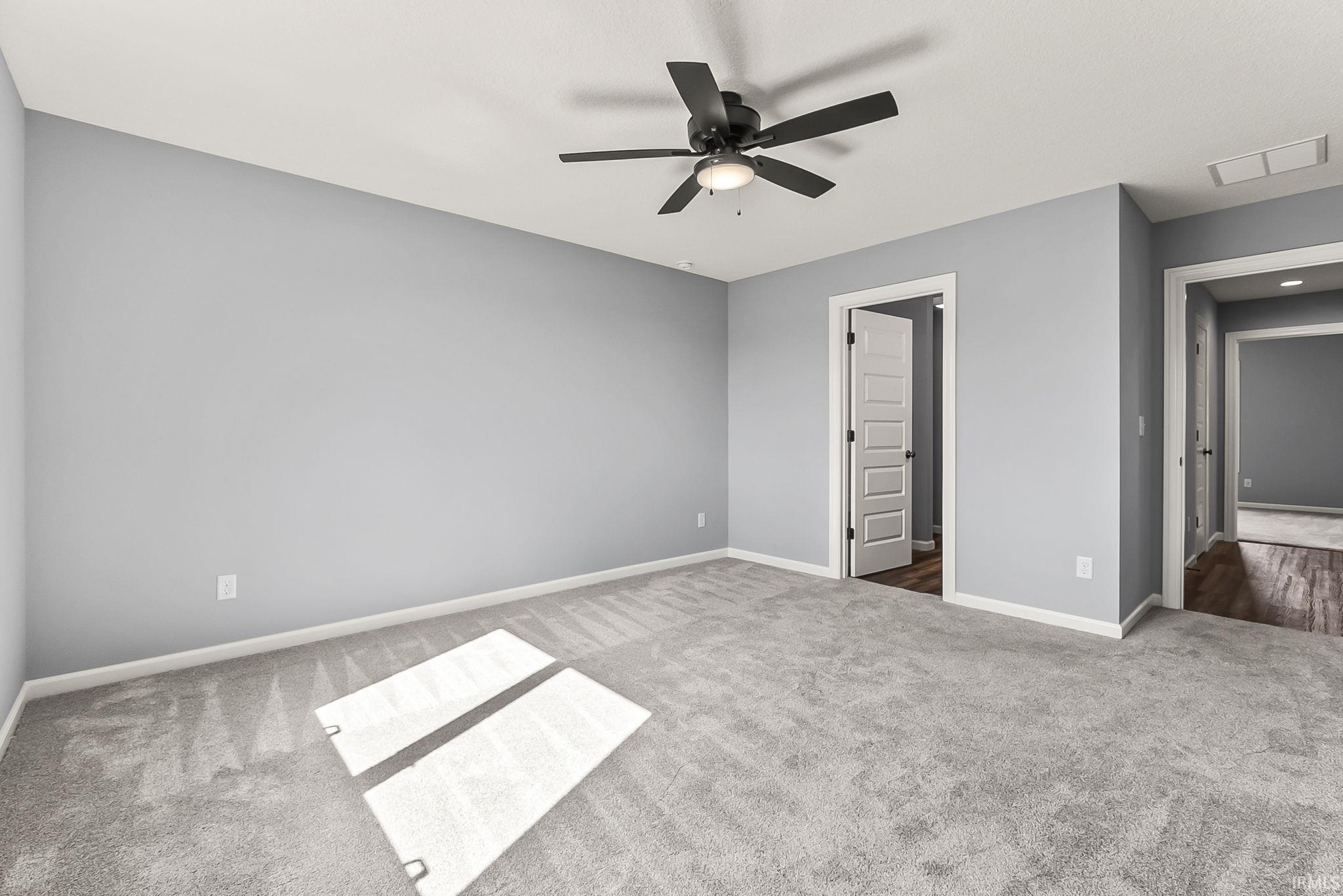 Unfurnished bedroom with a ceiling fan and carpet flooring