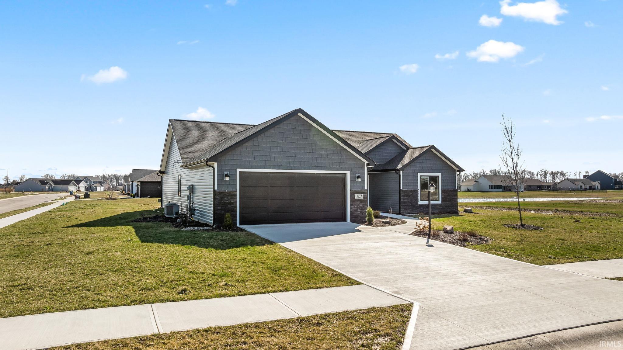 View of front of home featuring a residential view, concrete driveway, and a front lawn
