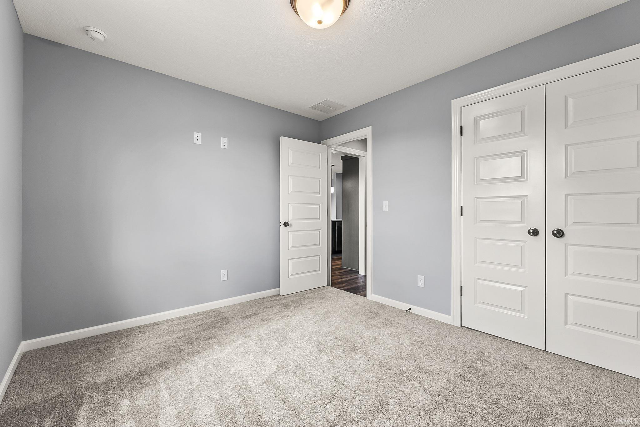 Unfurnished bedroom featuring carpet floors and a closet