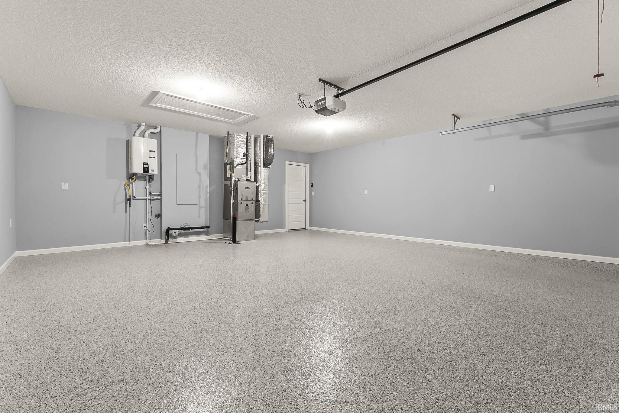 Garage featuring a garage door opener and water heater