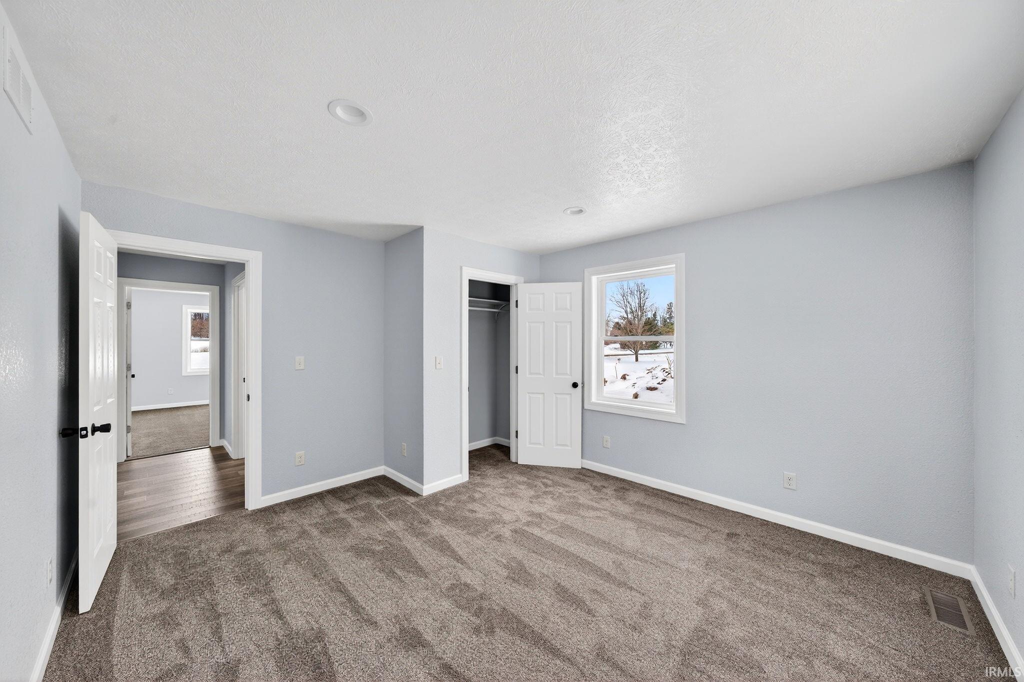 Unfurnished bedroom with carpet, a closet, and a textured ceiling