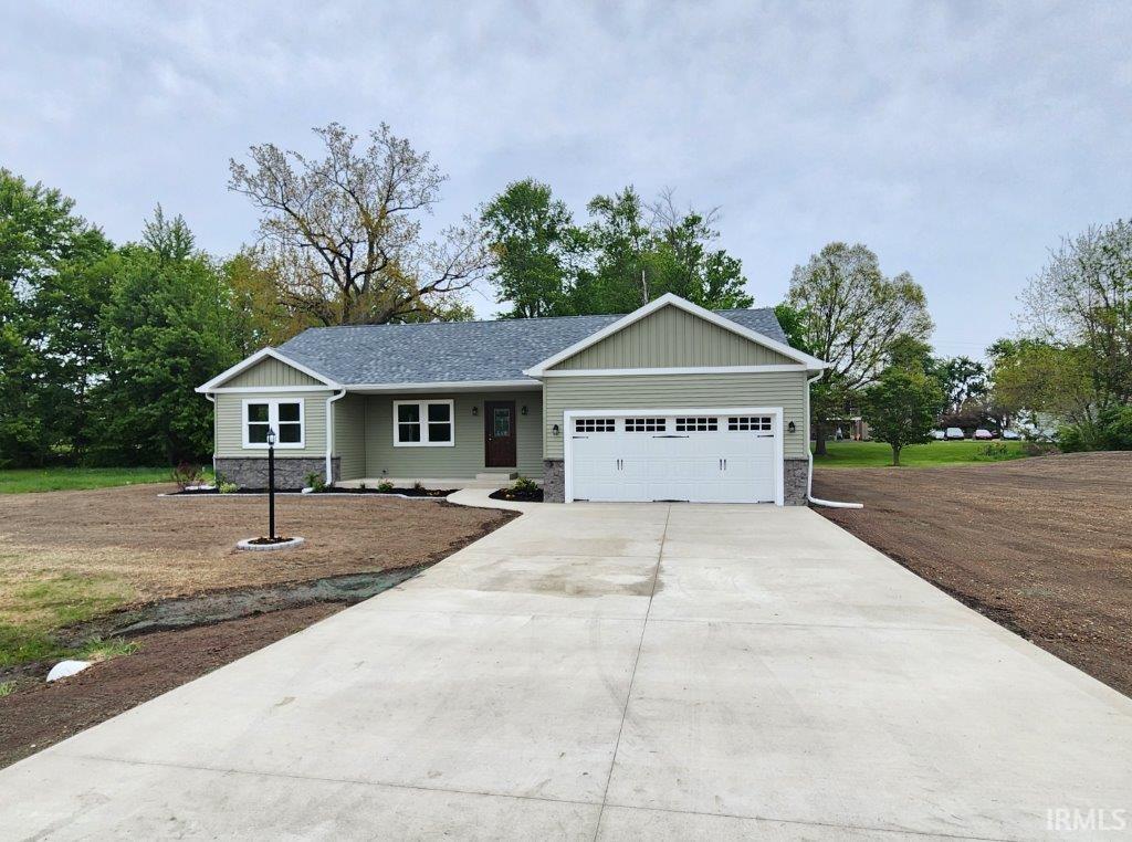Single-story residence featuring light green siding, a dark gray shingle roof, stone veneer accents, and white-framed windows