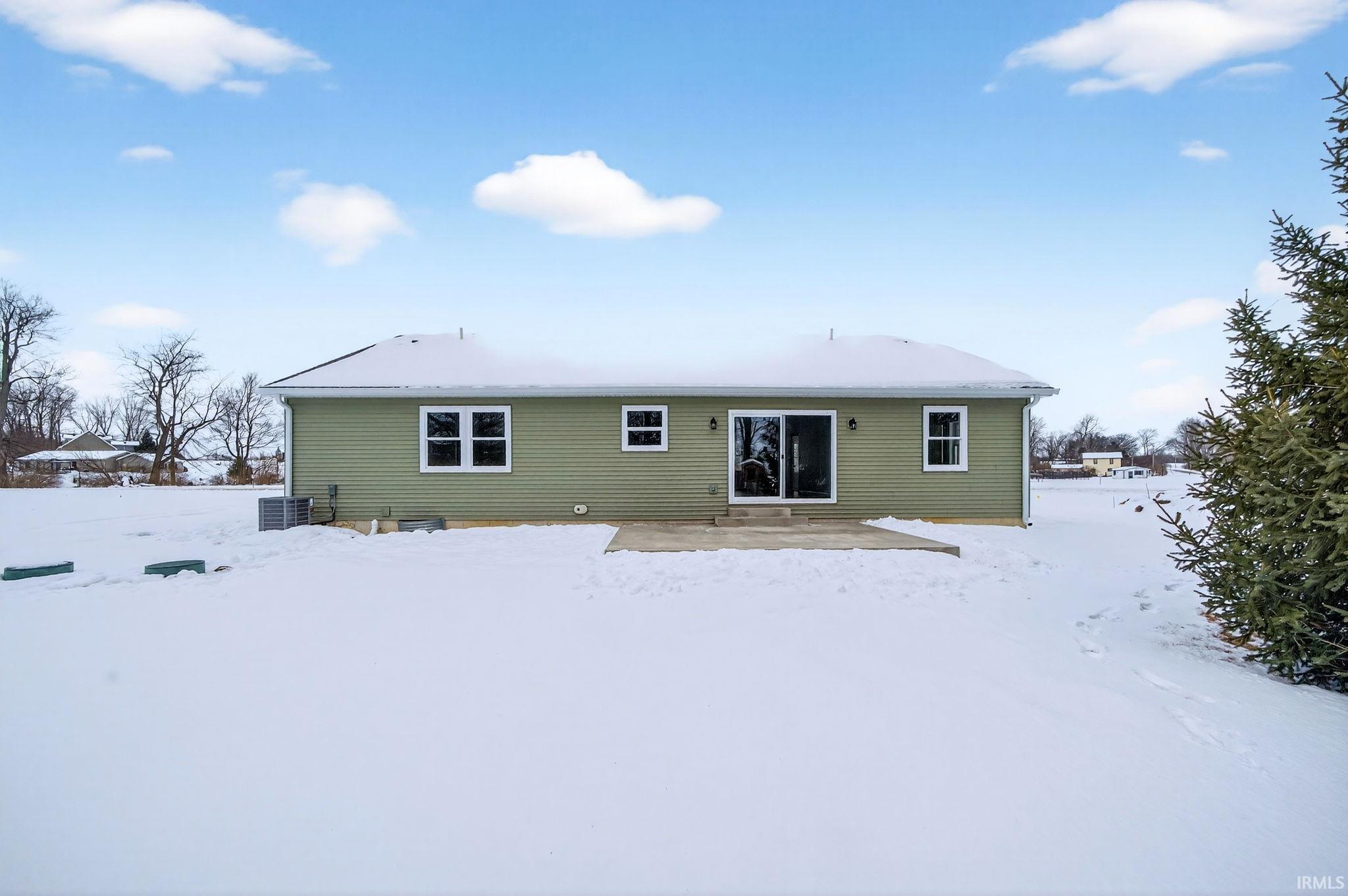 Snow covered property with a patio