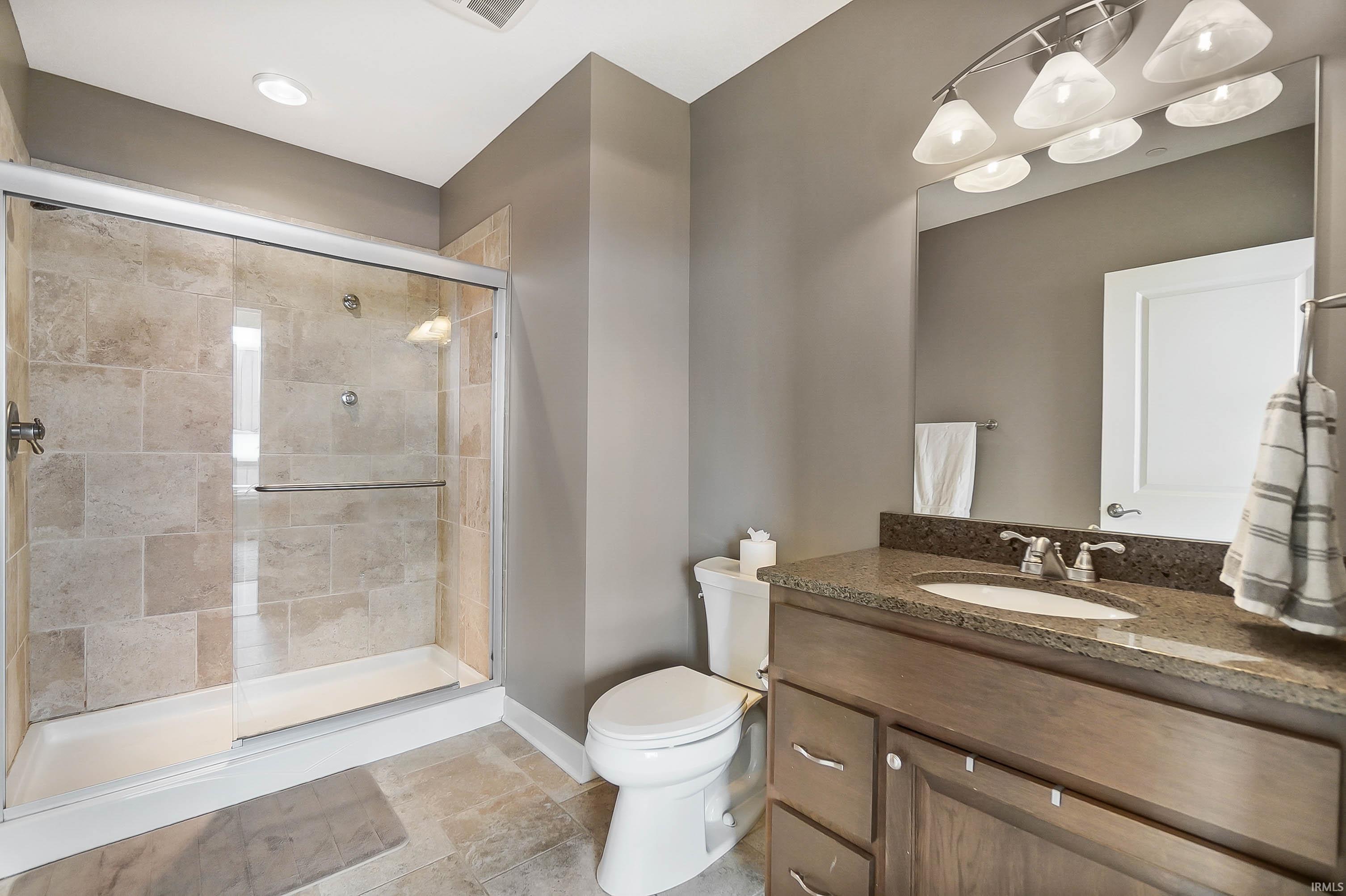 Full bath featuring vanity and a shower stall
