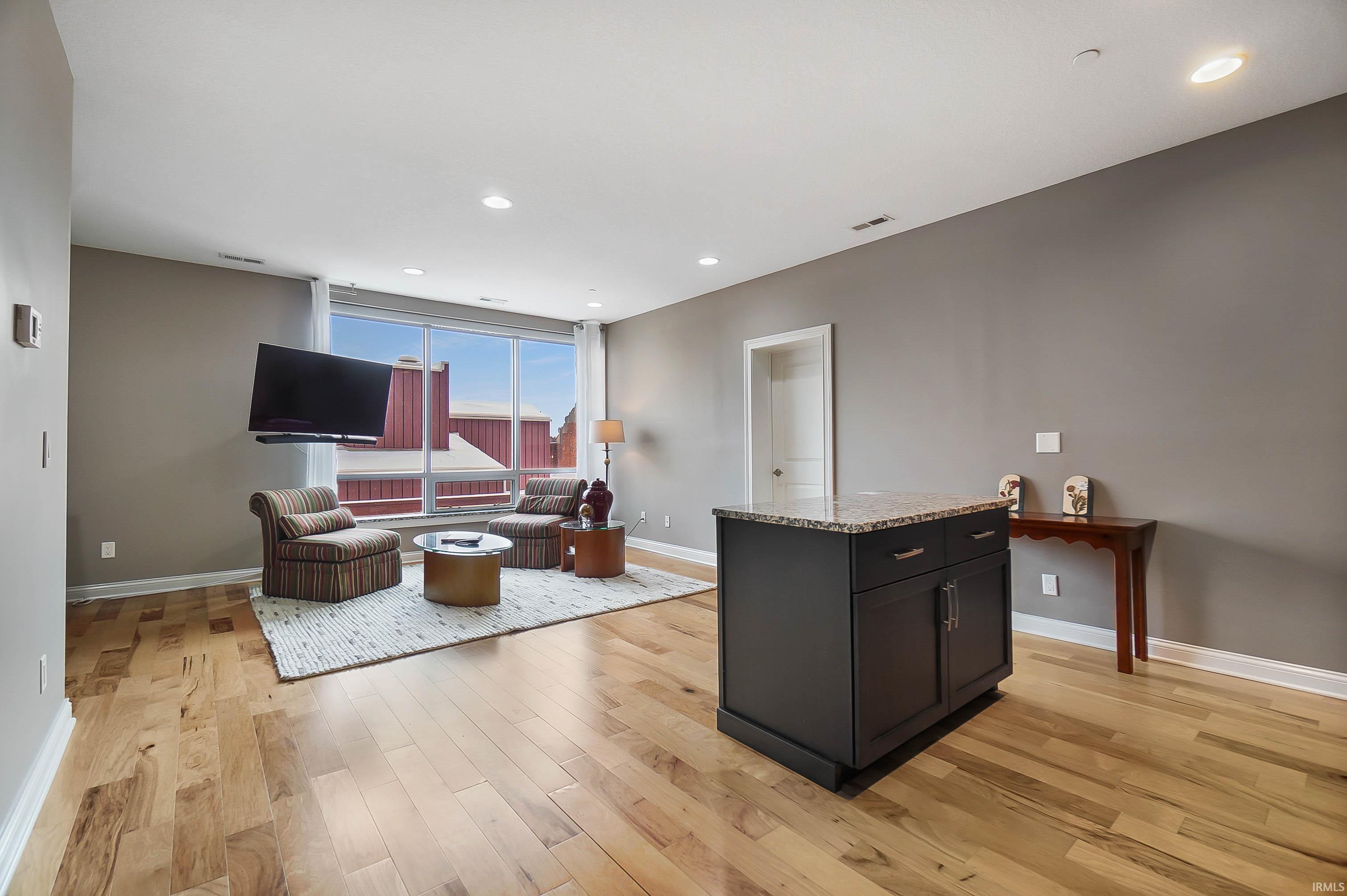Living area featuring light wood-style floors and recessed lighting