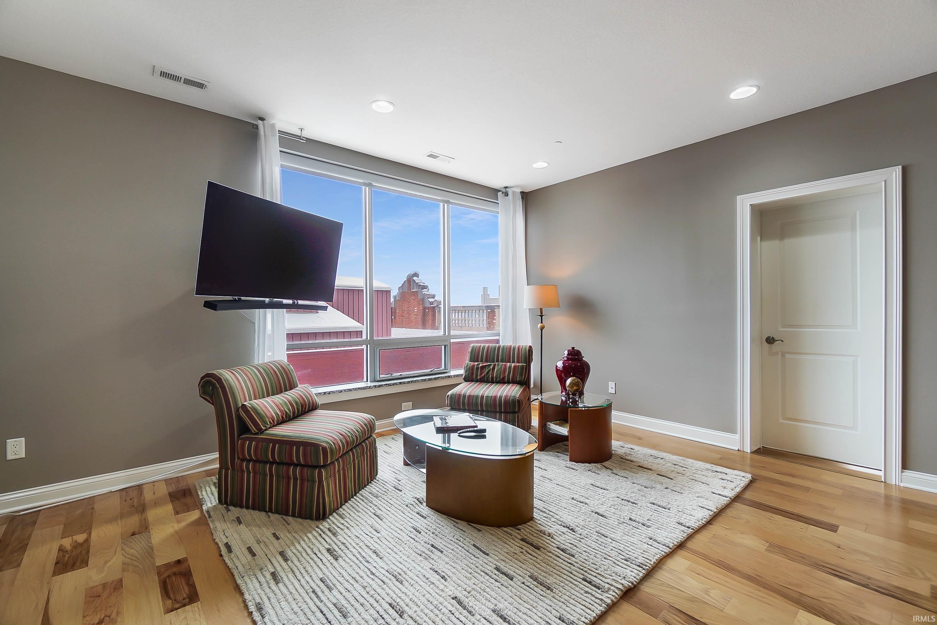 Living area with light wood-style flooring and recessed lighting