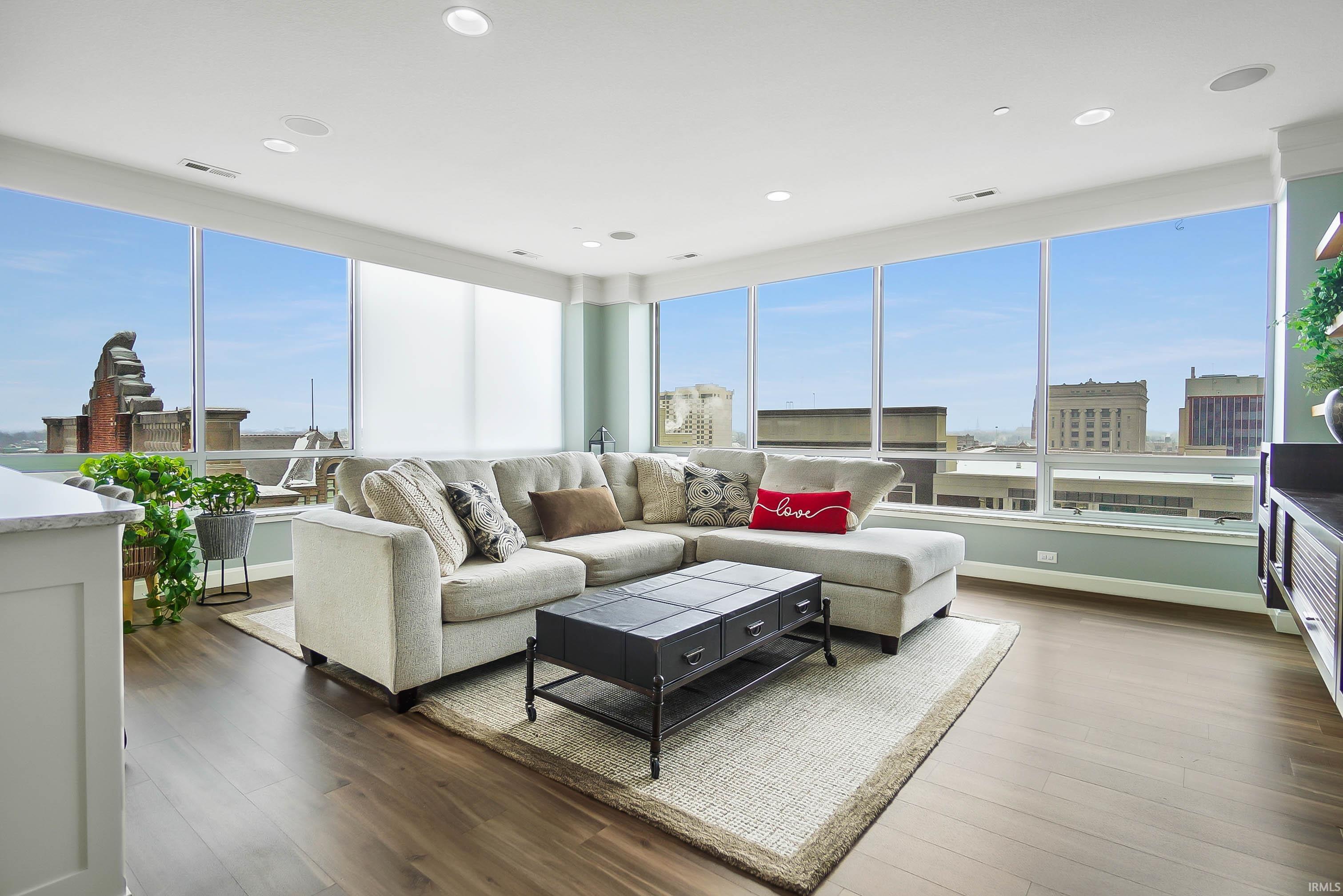 Living area with wood finished floors, healthy amount of natural light, and recessed lighting