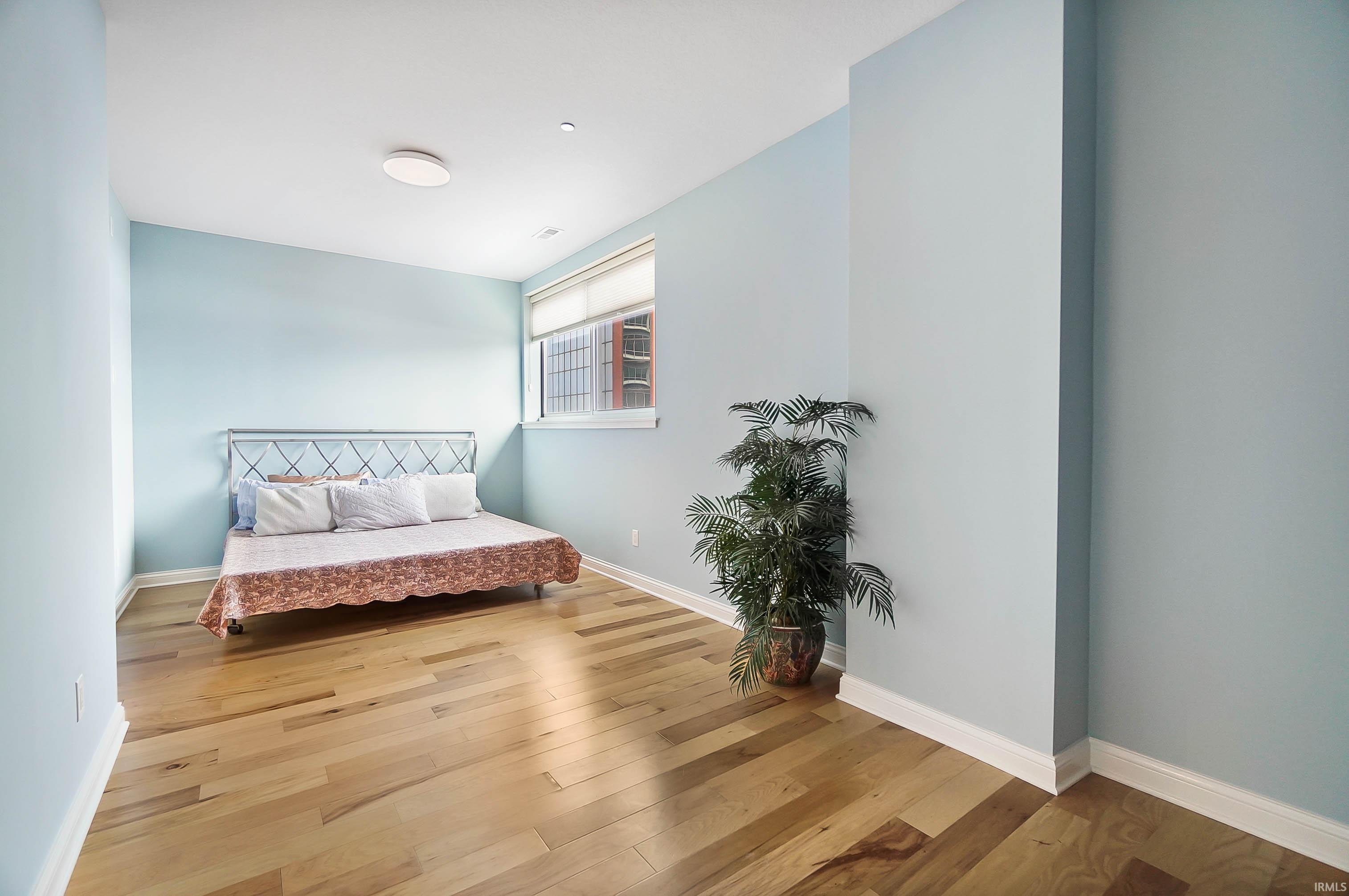 Bedroom featuring light wood-style flooring and baseboards