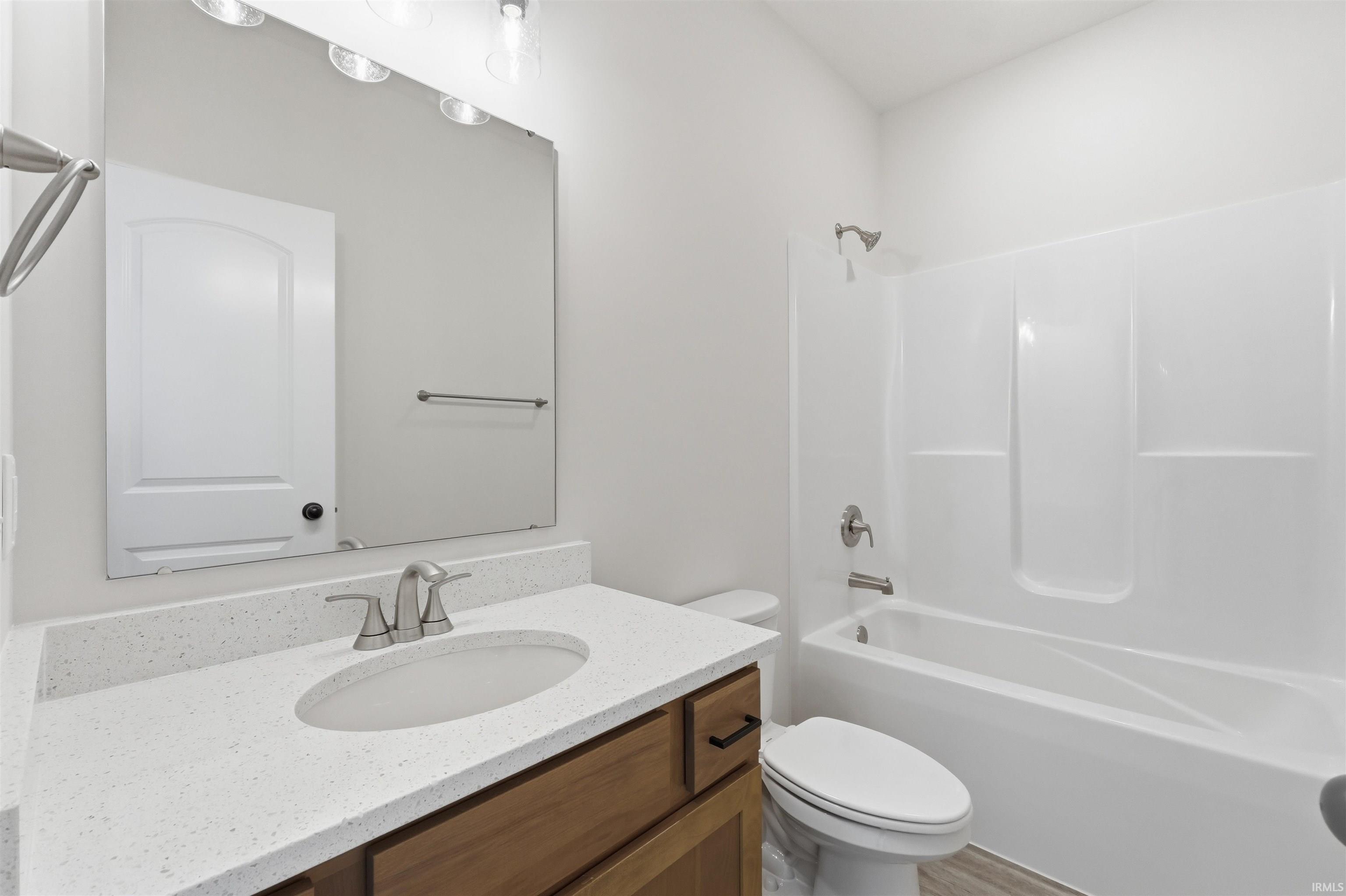 Main Bathroom featuring a quartz light-colored countertop, an undermount sink and a brushed nickel faucet.