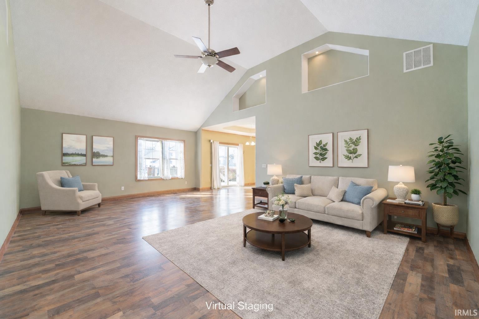 Living room with ceiling fan, dark wood-style floors, and a high ceiling