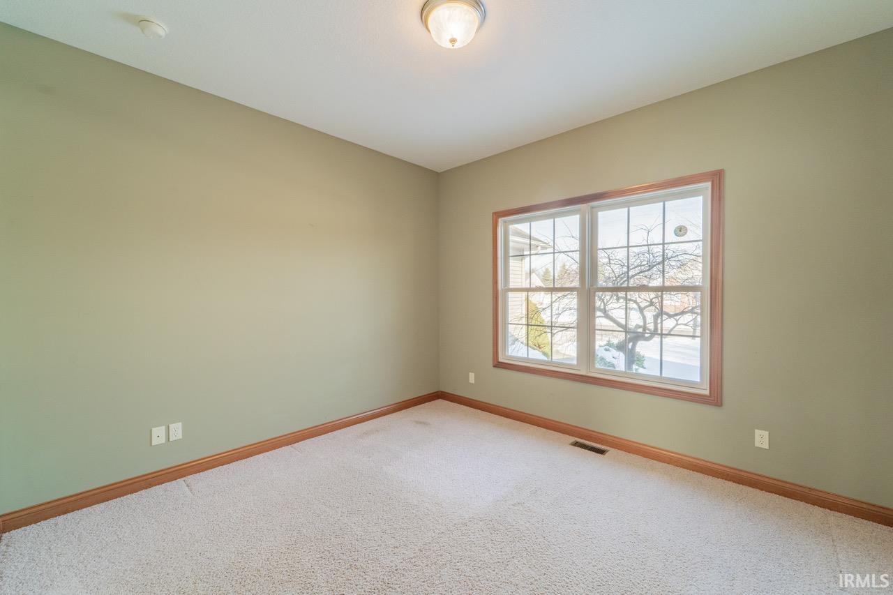 Spare room with carpet and baseboards