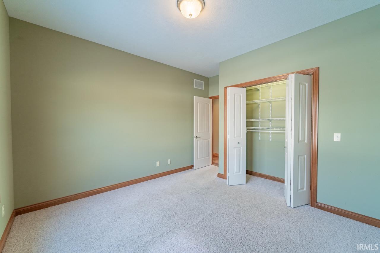 Unfurnished bedroom featuring light colored carpet and a closet