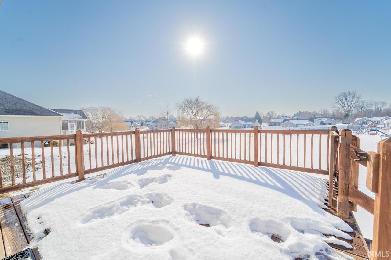 Snow covered deck with a residential view