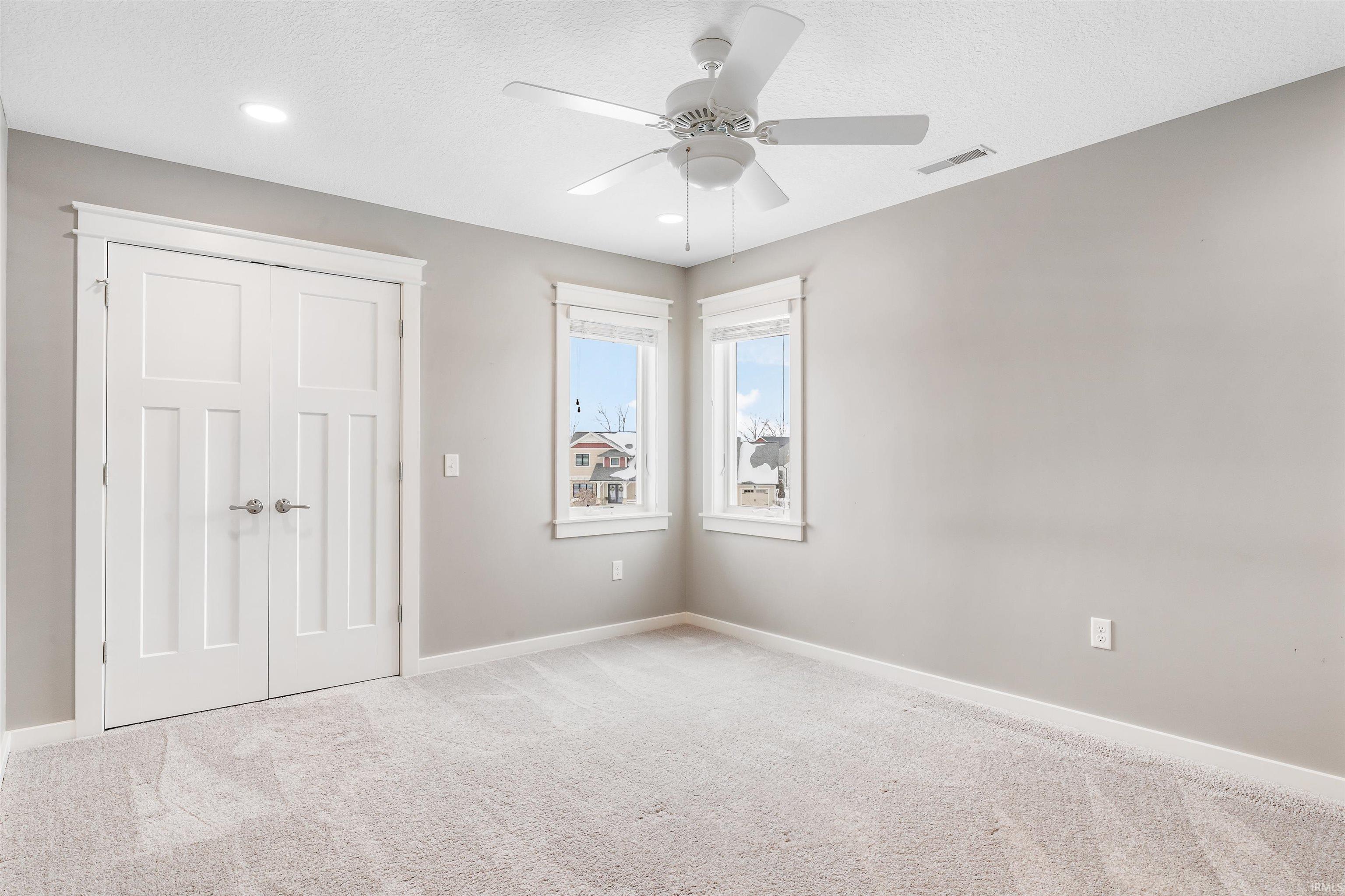 Unfurnished bedroom with carpet flooring, ceiling fan, a closet, and a textured ceiling