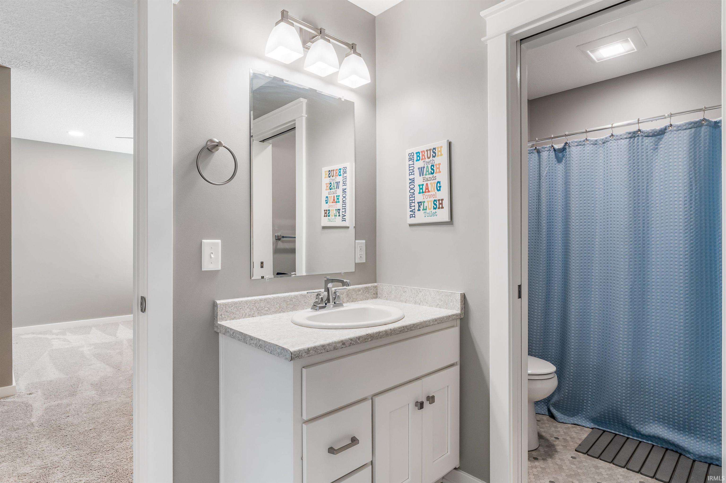 Full bath featuring vanity, a shower with shower curtain, a textured ceiling, and light colored carpet