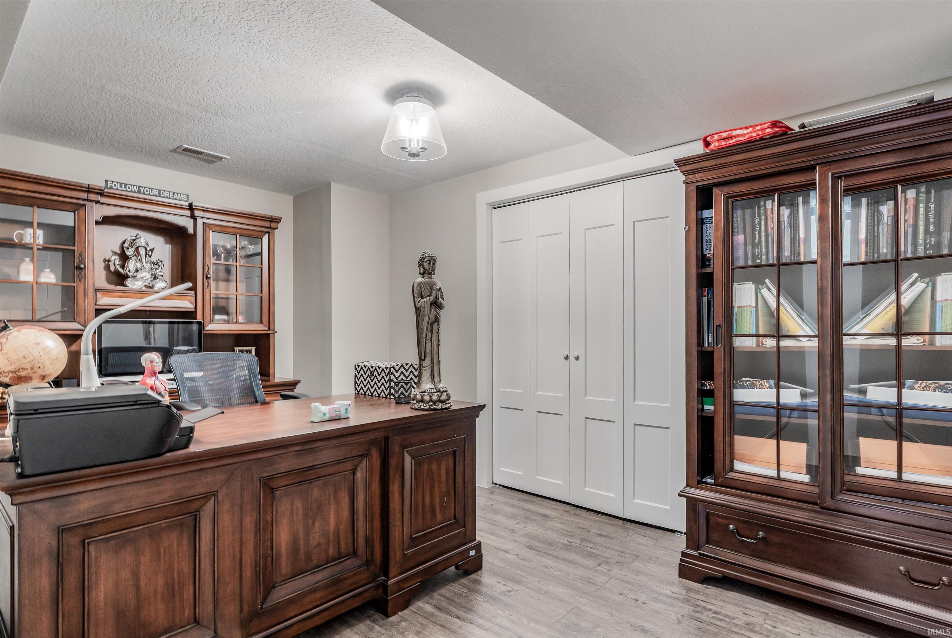 Office featuring light wood-style flooring and a textured ceiling