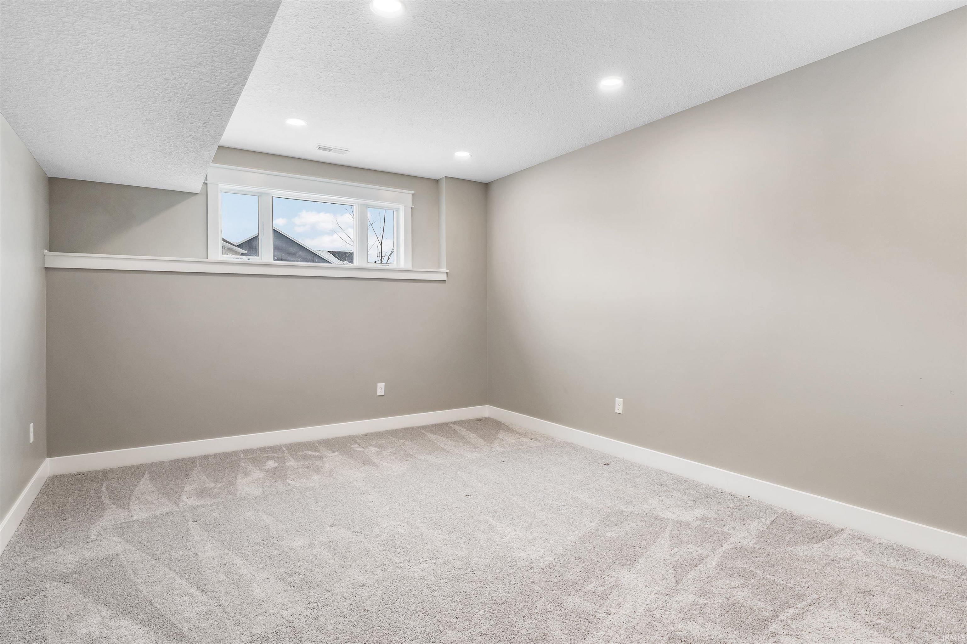 Unfurnished room with carpet floors, a textured ceiling, and recessed lighting