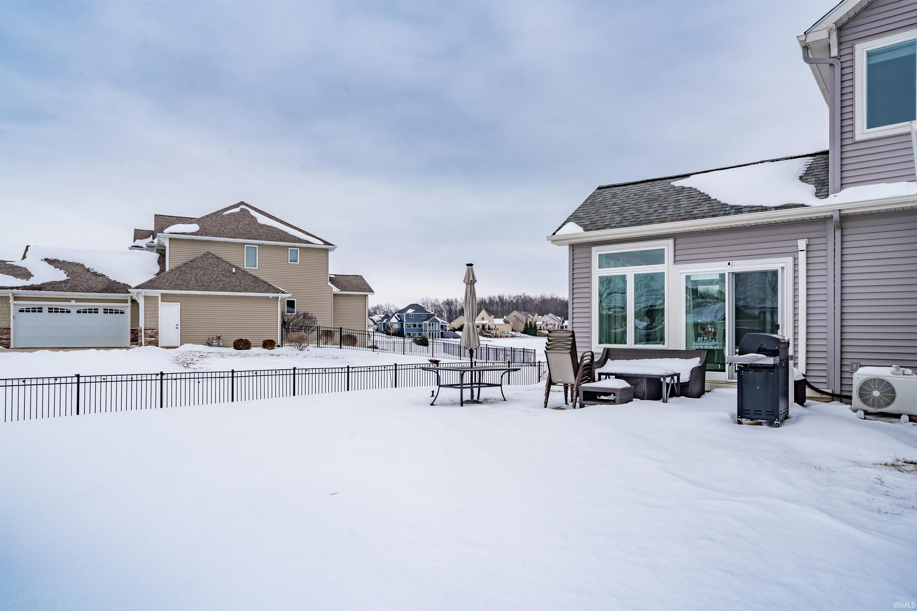 Snowy yard with a residential view and a patio area