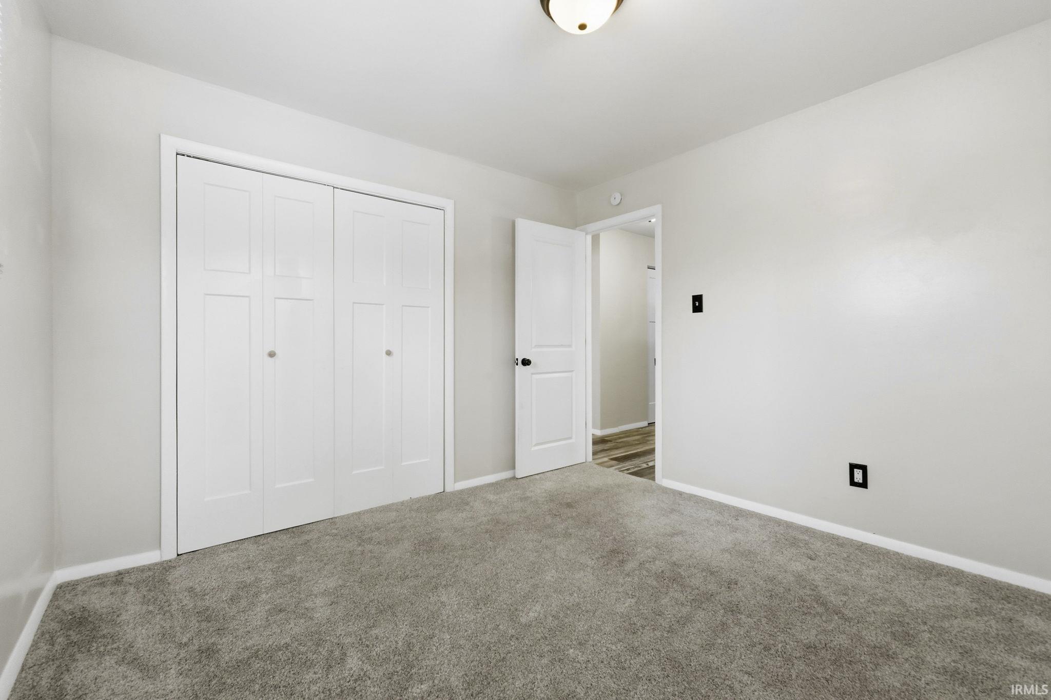 Unfurnished bedroom featuring carpet and a closet