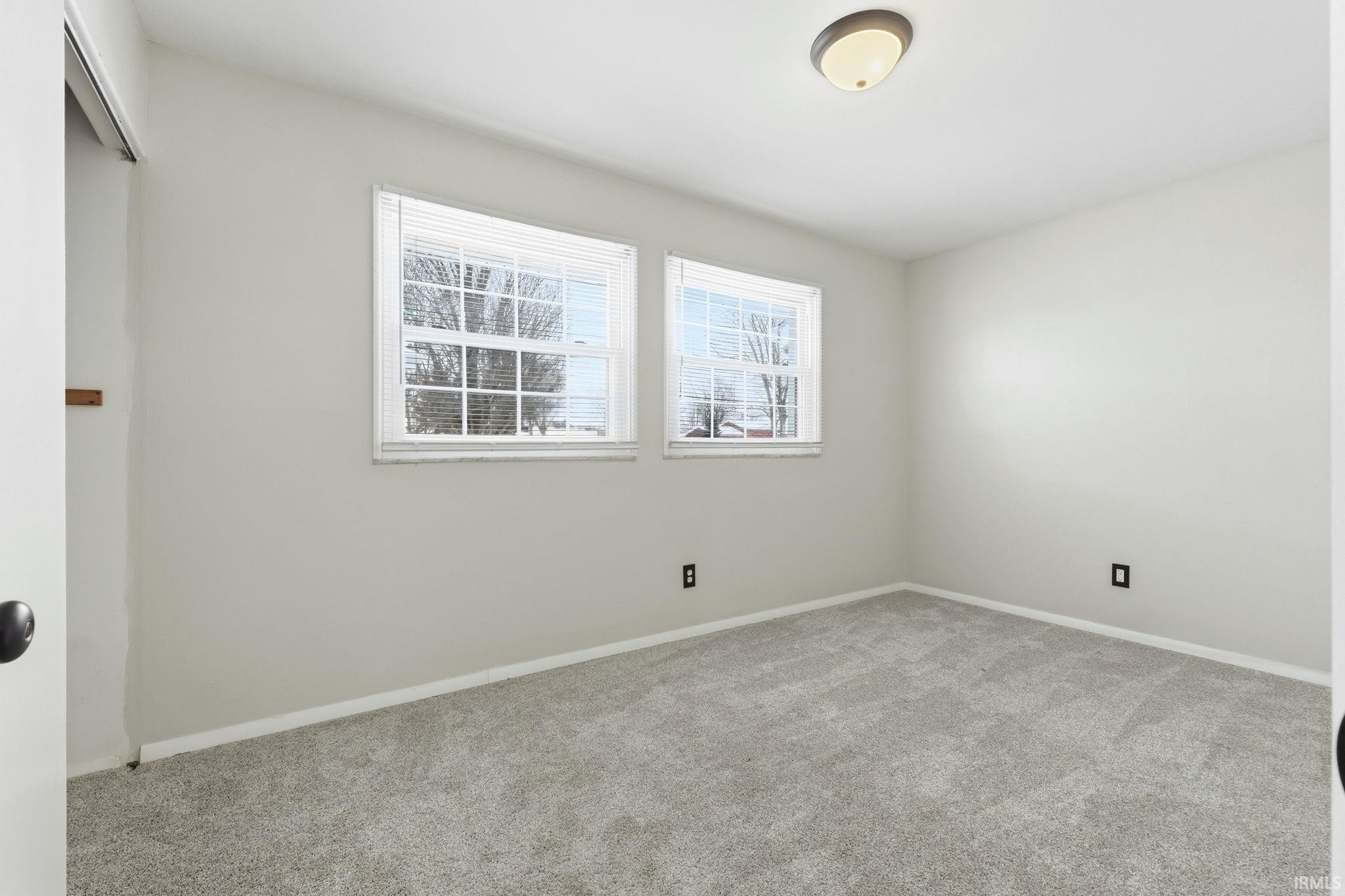 Empty room with carpet flooring and baseboards