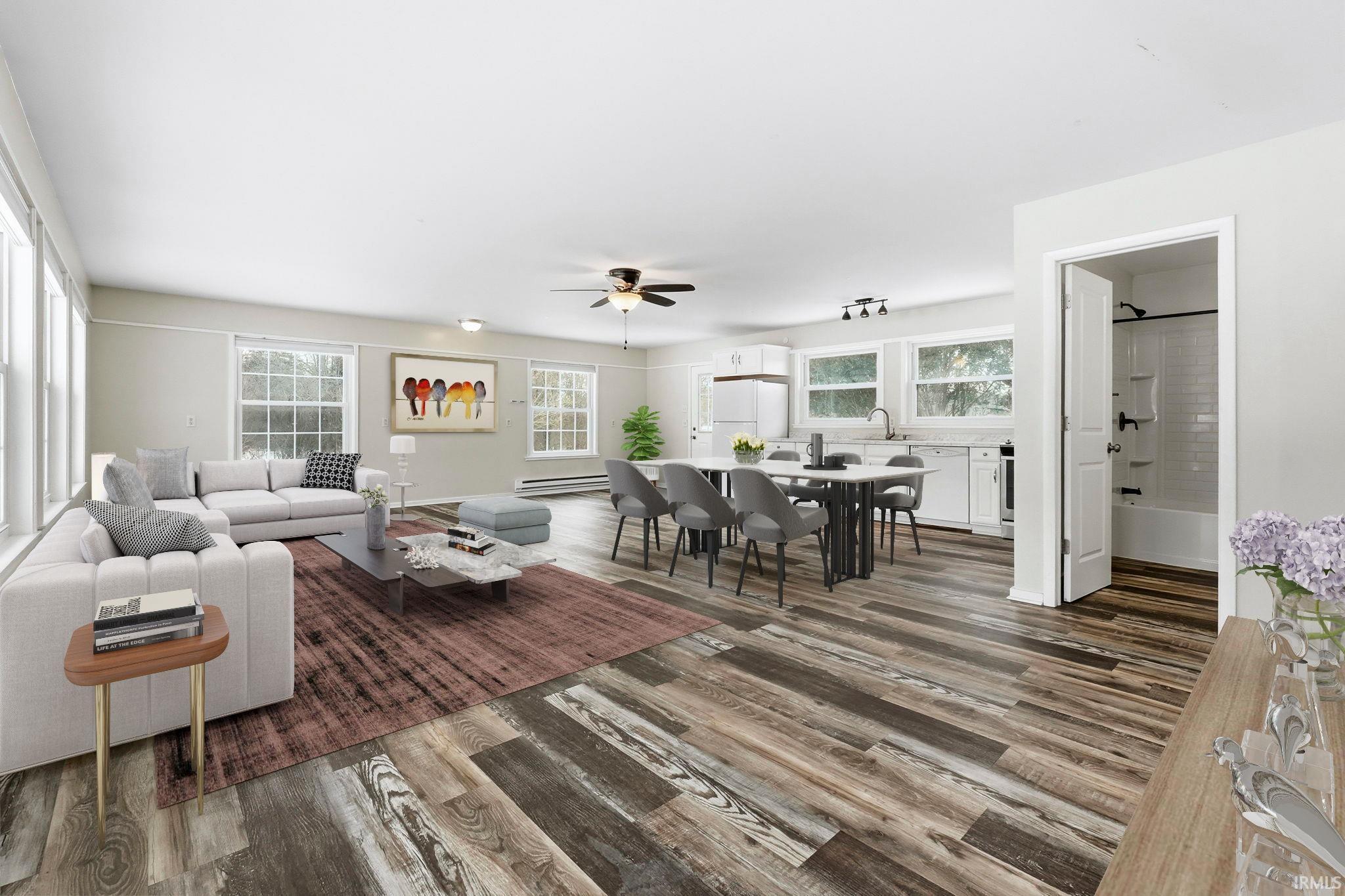 Living room with dark wood-style floors, a ceiling fan, and a baseboard heating unit