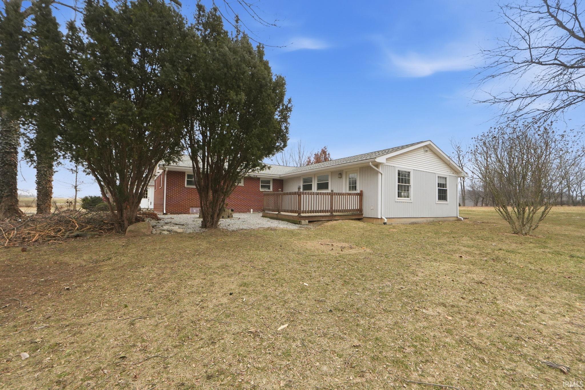 Rear view of property featuring a wooden deck and a yard