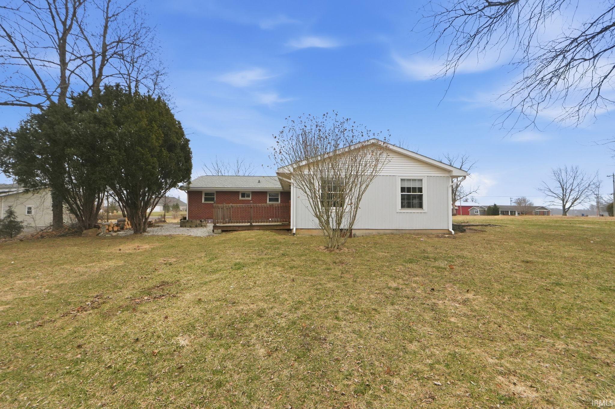 Back of property with a yard and a wooden deck