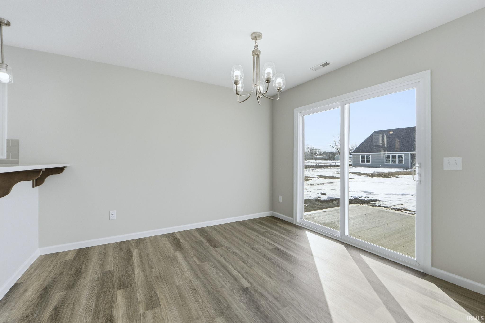 Unfurnished dining area with hanging lights and light wood-style floors