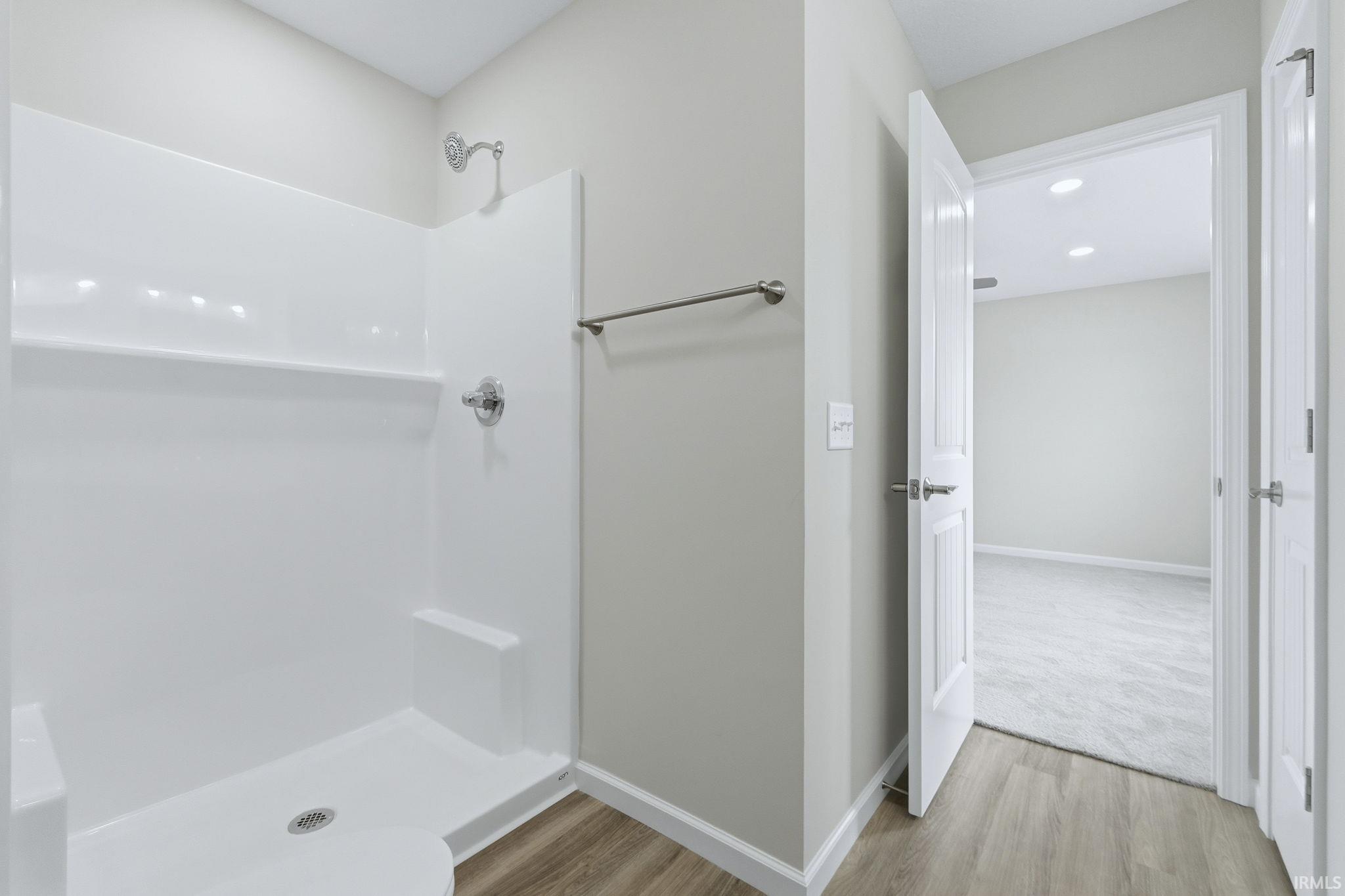 Bathroom featuring a shower stall, light wood finished floors, and recessed lighting