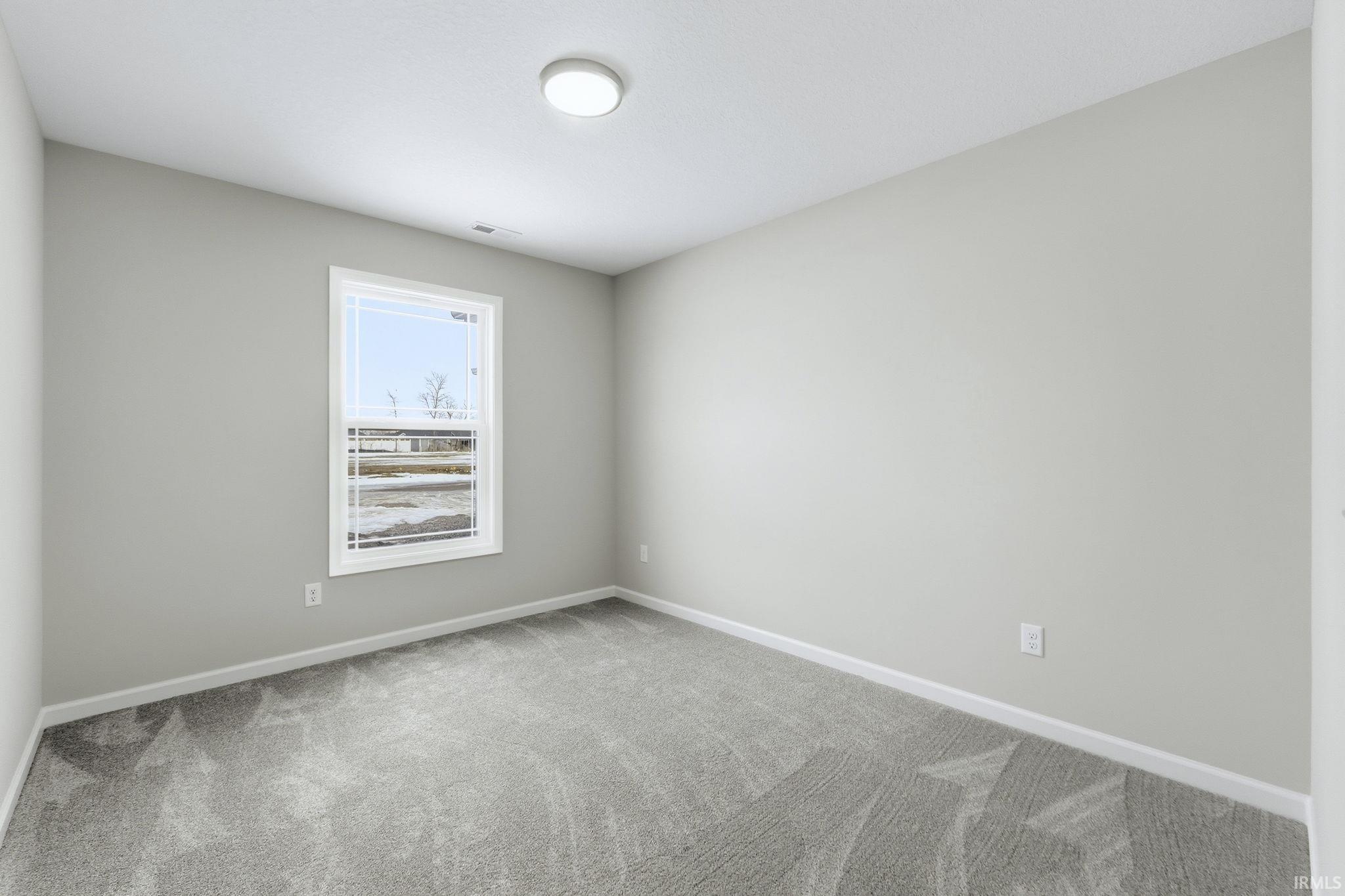 Carpeted empty room featuring baseboards