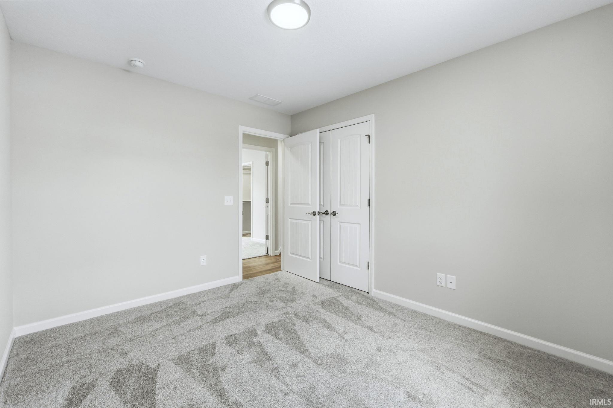Unfurnished bedroom featuring carpet flooring and a closet