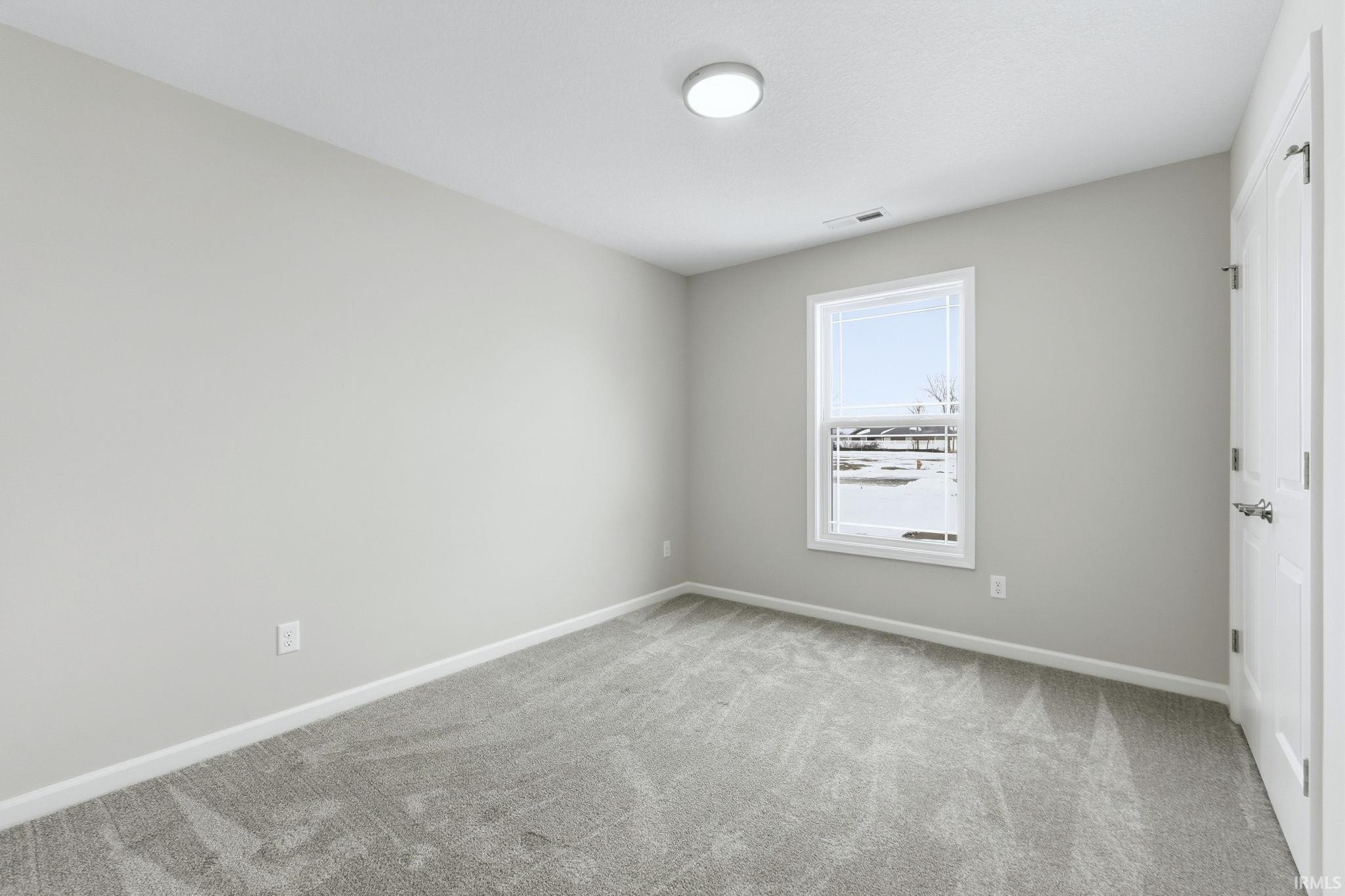 Unfurnished room with baseboards and light colored carpet